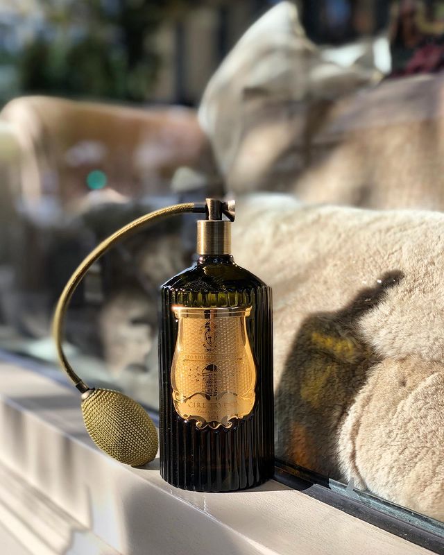 Vela perfumada Cire Trudon junto a un jarrón en Nomad Interiors